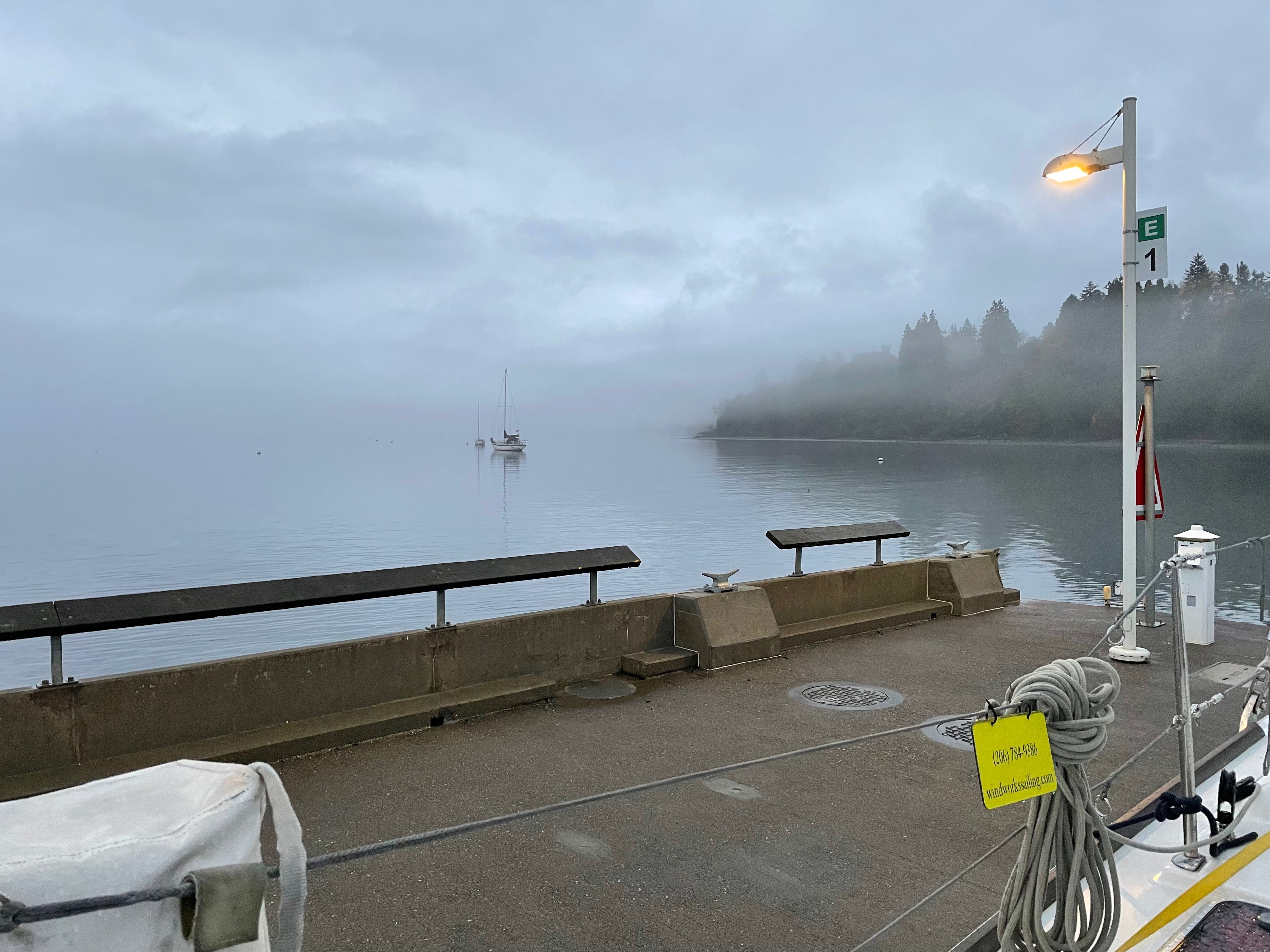 dock, moored sailboat in the fog