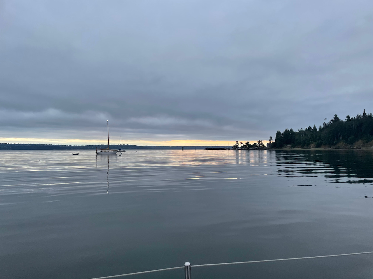 smooth water, boat moored in the foreground, island in the background