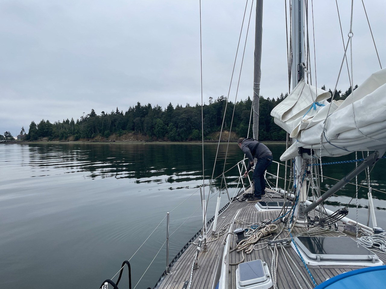 Shane putting lines away on deck with an island in the background