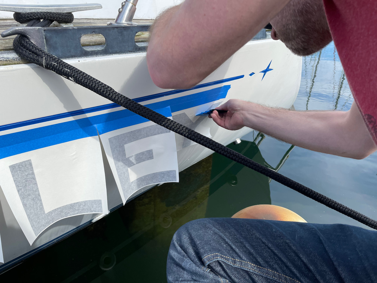 applying new vinyl letters to the boat